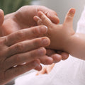 Hand eines Kleinkindes wird eingecremt