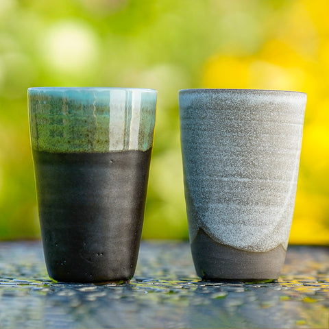 EM-Keramik Steinzeug Becher mit ca 350 ml Volumen. Paros (grau/beige) und Symi (schwarz/türkis).